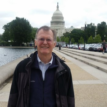 Robert stands next to a water feature, with the Capitol Building towering in the background