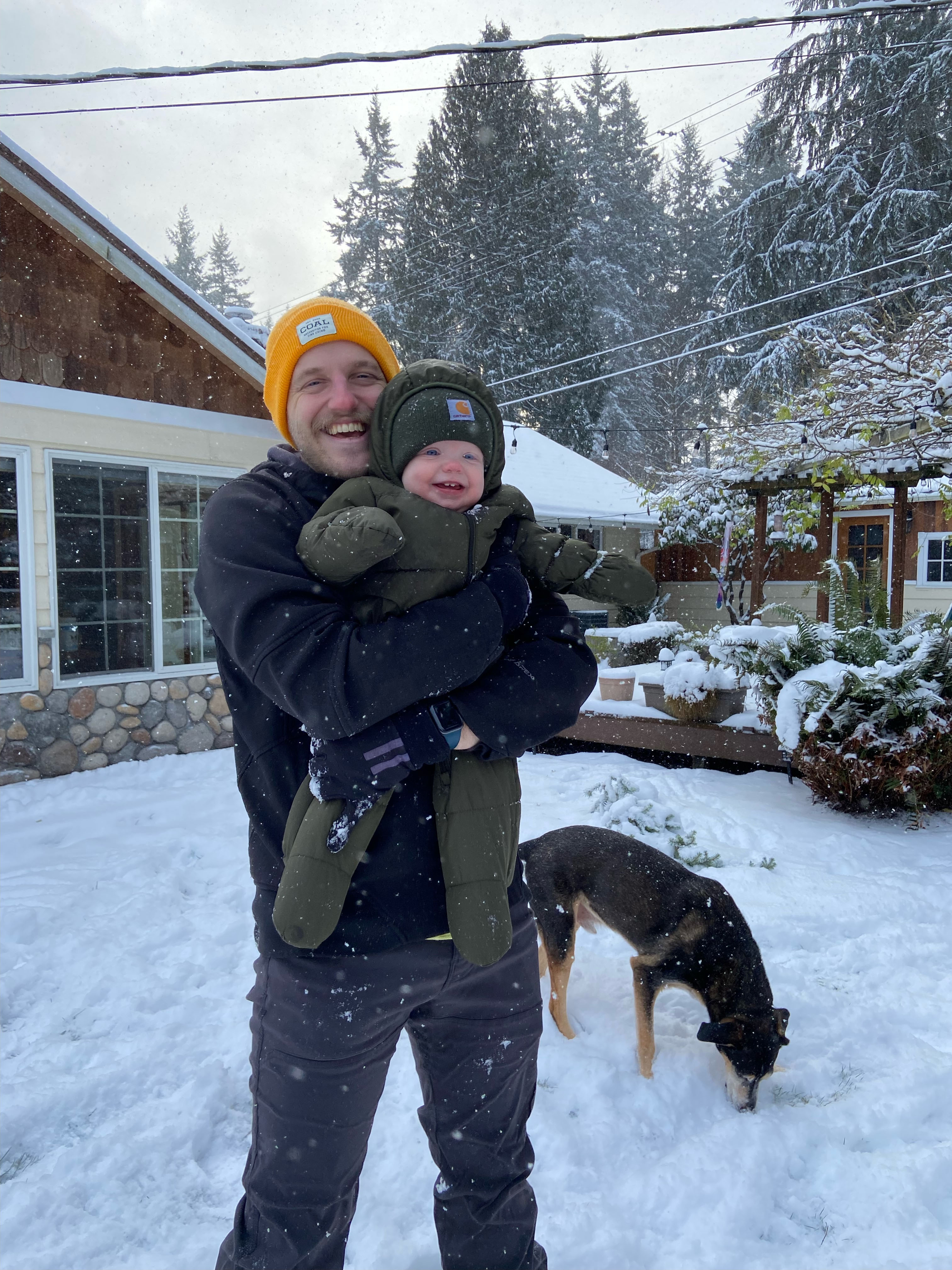 Nic Hartmann holding his child Jolene, outside on a snowy day.