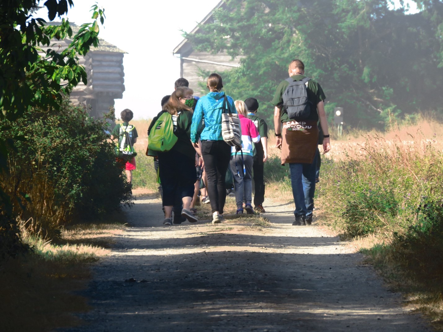 Group of adults and children walking down a gravel path