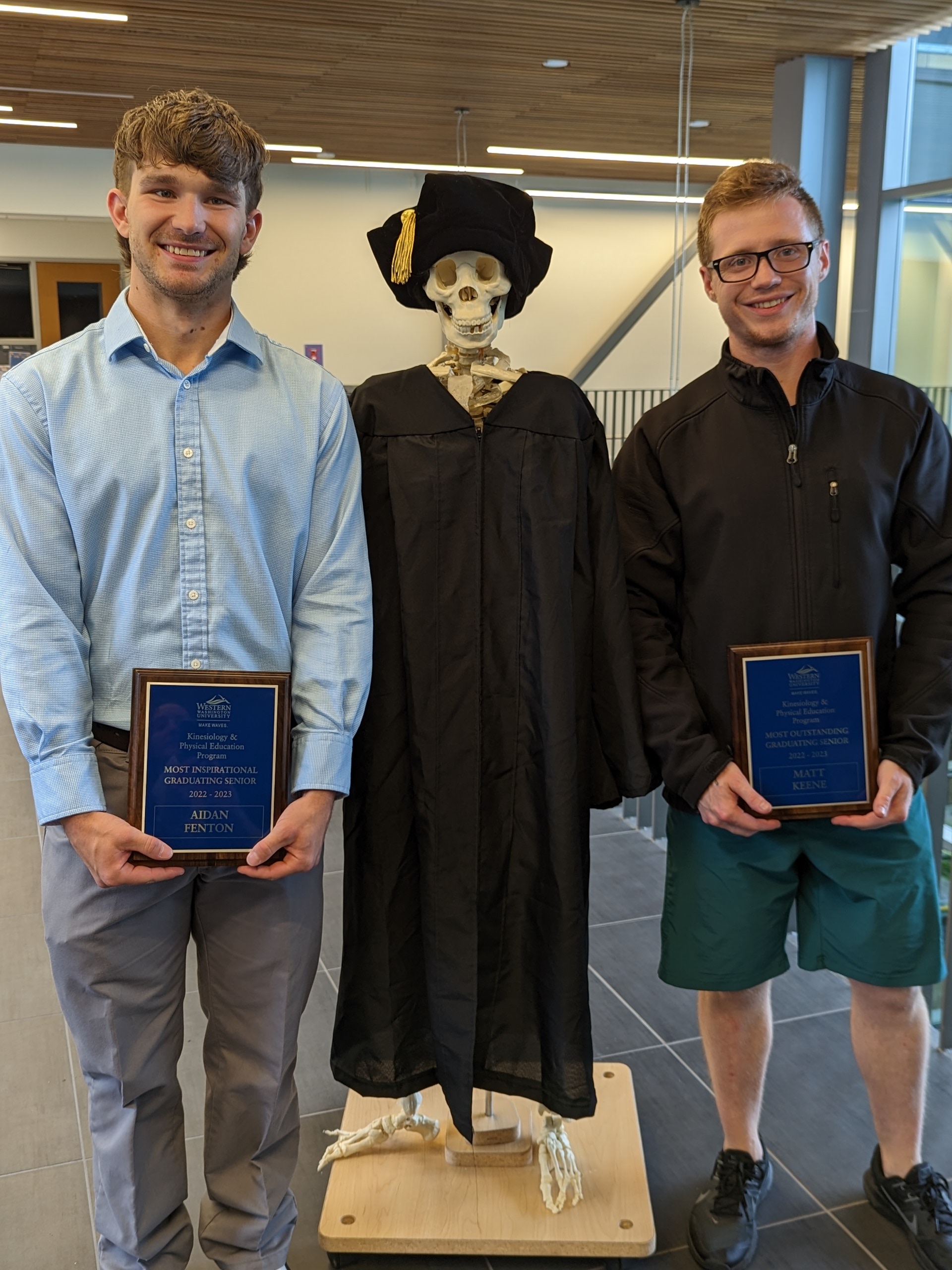 Aidan, Matt and Skeleton standing in hallway with awards