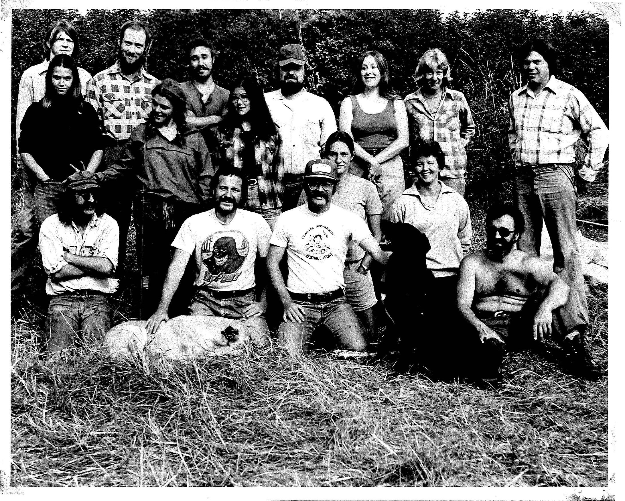 archaeology students and a black dog pose in a field circa 1970