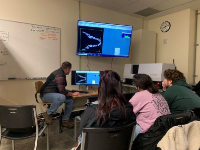 students gathered around a micro CT scanner in class