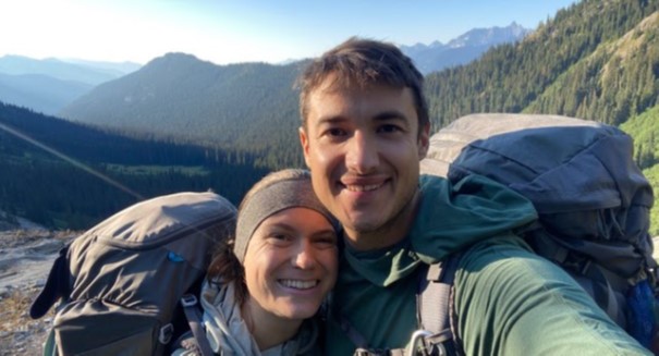 selfie photo of Anthony and Michelle Nault PHIL '13 with the North Cascades forest in the background