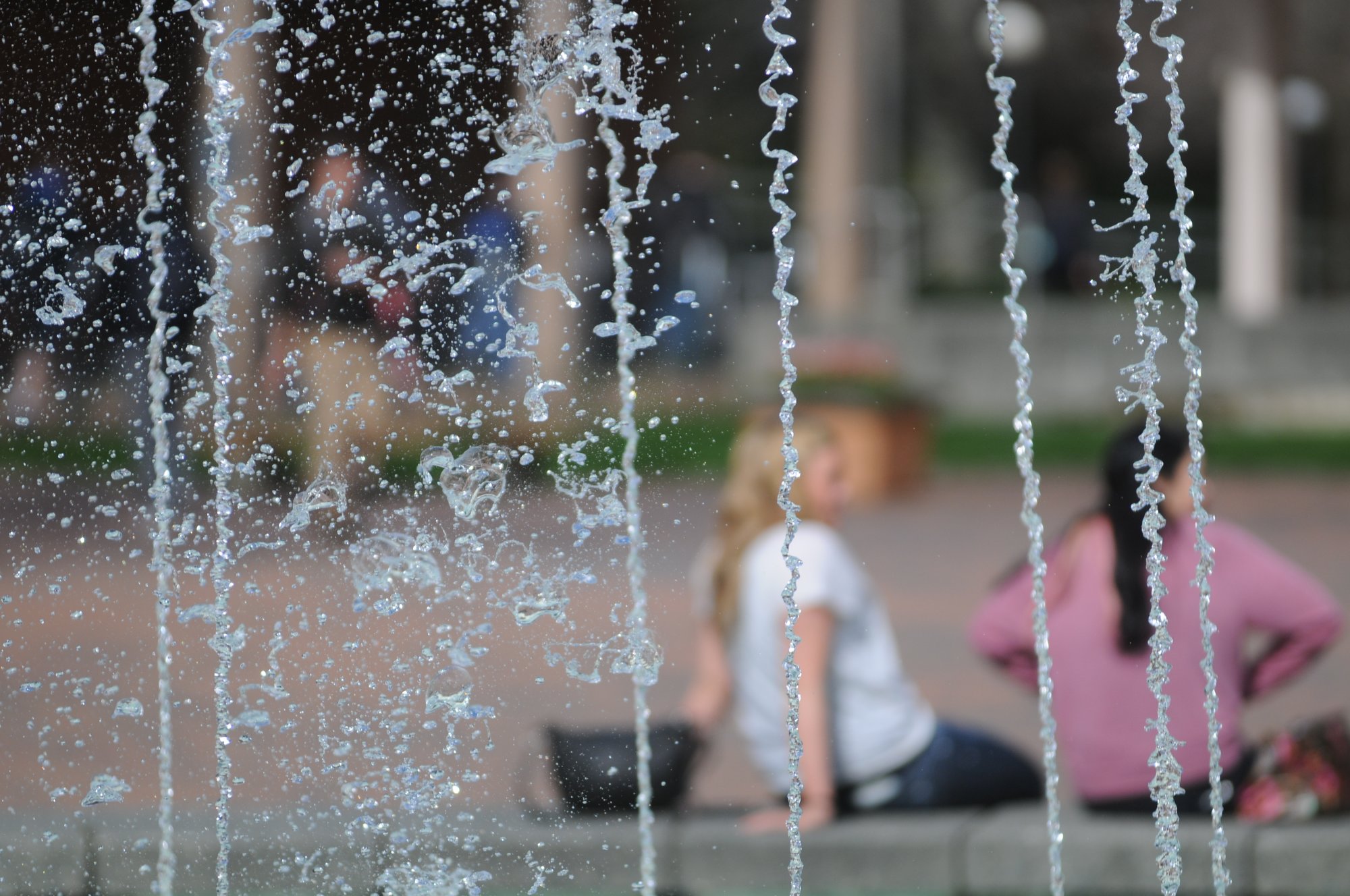 Fountain in Red Square at Western Washington University with people sitting in background.