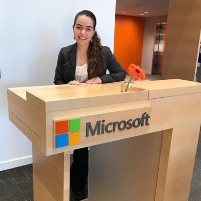 Bahar wearing suit and standing behind podium with Microsoft logo