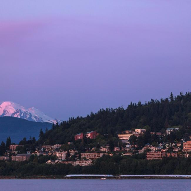 Western Washington University off of Bellingham Bay at dusk, Mount Baker can be seen in the distance.
