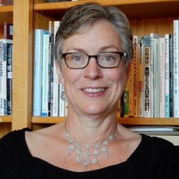 Headshot of Professor Julia Sapin in front of a bookshelf.