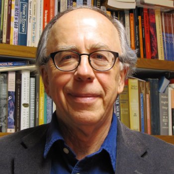Prof. Stewart with a bookshelf behind him