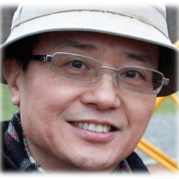 Dr Wang wearing glasses and a hat
