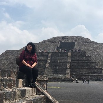 Melina Juarez sitting in front of a pyramid