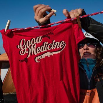 Kristin hangs a red "Good medicine" t-shirt on a clothesline and wears athletic gear