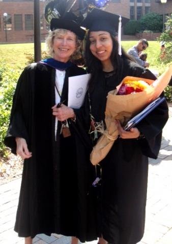 Professor Sara Weir and amanjeet Sahota pose together in ceremonial graduation gowns
