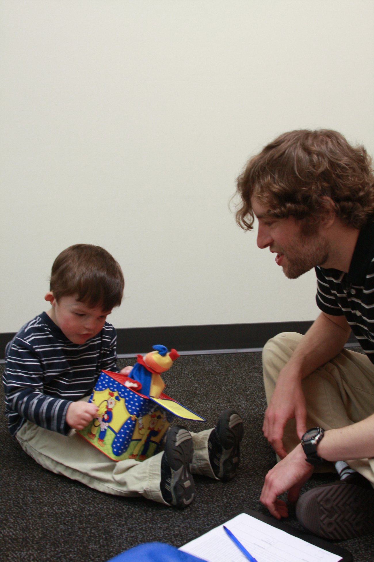 a child plays with a jack in the box while a pathology student watches.