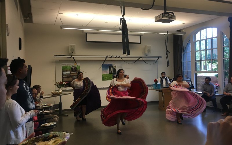 Students dancing with large skirts in a classroom