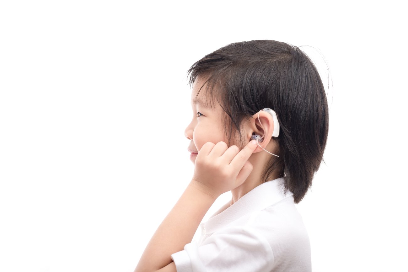 Little boy showing his cochlear implant
