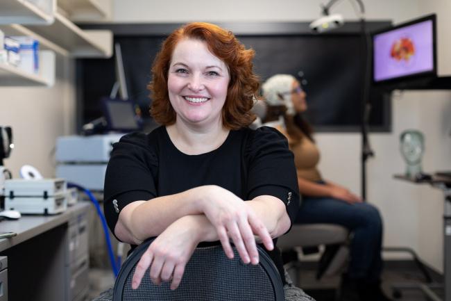 Dr. Chantel Prat smiling with arms crossed, with a lab in the background