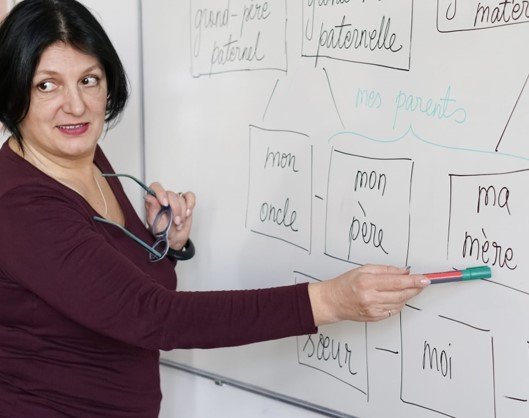French language teacher pointing to whiteboard