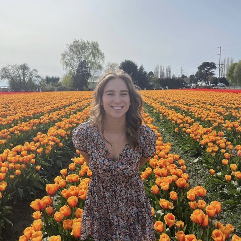 Smiling woman in a dress standing in a field of tulips