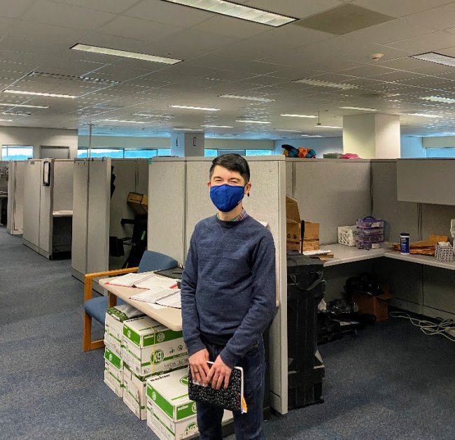 Man in mask standing in an office