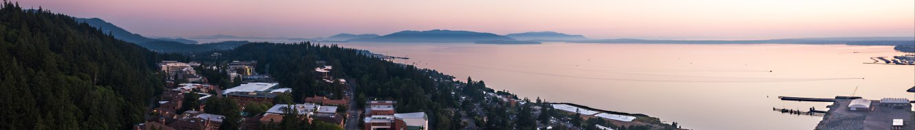 Aerial view of Western's forested campus situated near Bellingham Bay at sunset