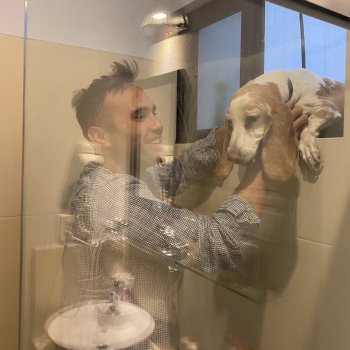 Reflection of Prof. Ernest Rafael Hartwell lifting a dog through a window
